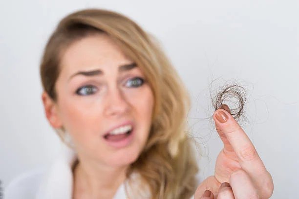 a woman holding up her finger with a hair fall